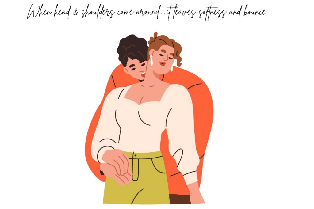 A young couple cuddling with the young man wrapping his arms around the young woman from behind.